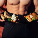 topless man in black shorts holding cooked food